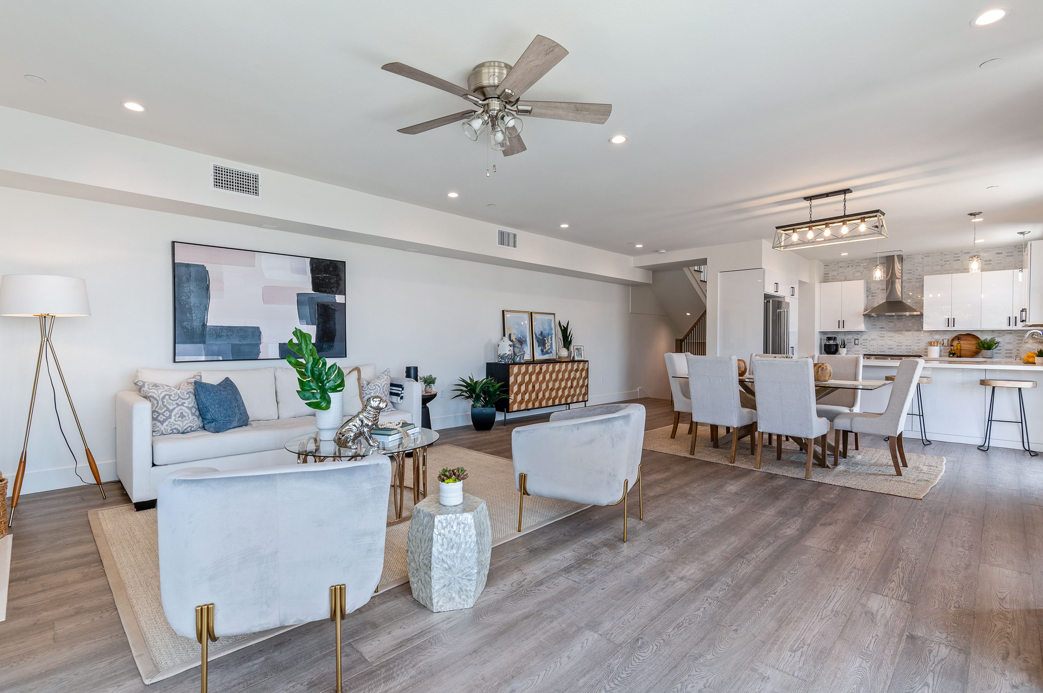 Staged open-plan living, dining, and kitchen — new construction home staging